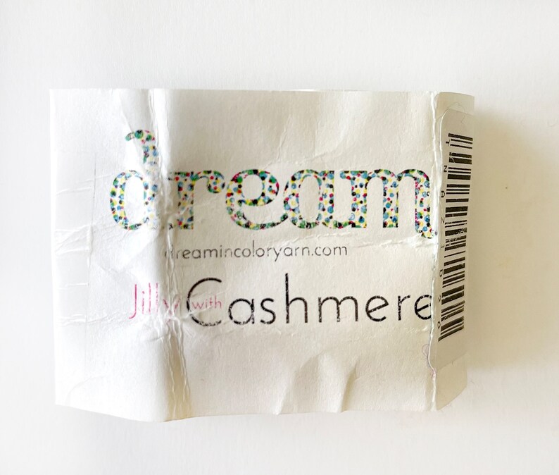 May include: A white label with the word "dream" in colorful letters, the website "dreamincoloryarn.com", and the text "Jilly with Cashmere".