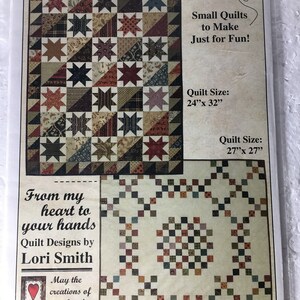 May include: A pattern for small quilts, featuring two quilt designs. The top quilt has a star pattern with various fabric prints. The bottom quilt has a square pattern. The text reads "Quaint Little Quilts #6" and "Small Quilts to Make Just for Fun!"