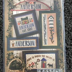 May include: A package for a craft project titled "Name Games" featuring various embroidered designs. The designs include the name "ANDERSON" in multiple styles, a house, a basket, and the phrase "HOME IS WHERE THE HEART IS". The package is from "cabbage rose".