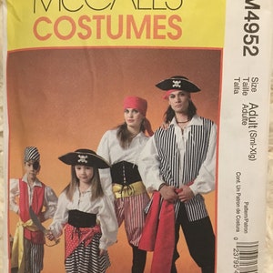 May include: McCall's Costumes pattern for pirate costumes. The pattern includes instructions for adult and child sizes. The image shows several people wearing pirate costumes, including striped shirts, bandanas, and pirate hats with skull and crossbones.