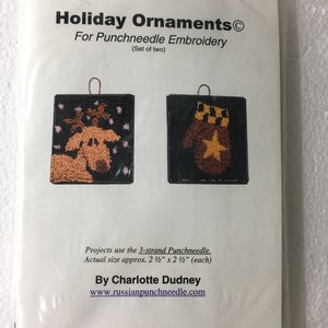 May include: A package of "Holiday Ornaments" for punchneedle embroidery. The set includes two square ornaments, one with a reindeer design and the other with a mitten and star. Each ornament is approximately 2.5 inches by 2.5 inches.