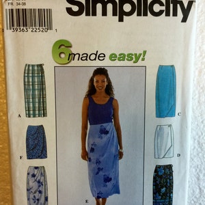 May include: Simplicity sewing pattern 8527 featuring six skirt designs. The pattern includes a woman wearing a blue floral wrap skirt. The pattern also shows skirt designs with plaid, floral, and solid color options.