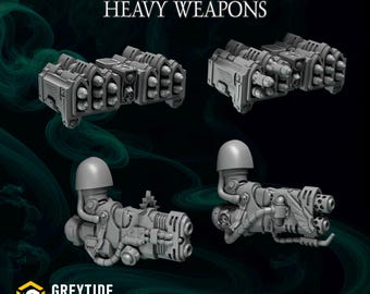 Può includere: Un set di miniature di armi pesanti grigie che include due lanciarazzi a più canne e due cannoni pesanti con spallacci. Il testo ETERNAL PILGRIMS HEAVY WEAPONS è visualizzato in alto e il logo GREYTIDE STUDIO è in basso.