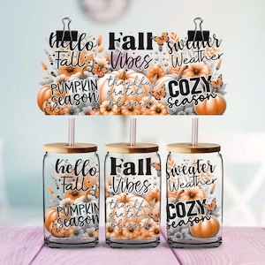 May include: Three clear glass tumblers with bamboo lids and straws, each featuring a wrap-around design of orange pumpkins, autumn foliage, and butterflies. The text reads hello Fall, Fall Vibes, thankful grateful blessed, pumpkin season, and cozy season.