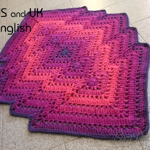 May include: A crocheted square blanket with a gradient of pink, purple, and dark purple. The blanket has a scalloped edge and is made with a textured stitch.