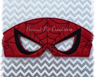 May include: Red felt mask with black eye holes and a black web design. The mask says "Peanut Pie Creations" in black text.
