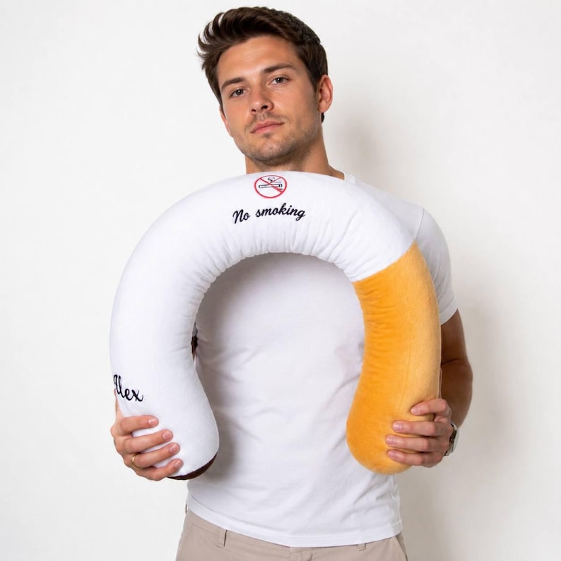 May include: A large novelty pillow in the shape of a cigarette. The pillow is white with a tan end and a brown tip. It features the words "No smoking" and a no smoking symbol. The name "Alex" is embroidered on the side.