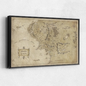 May include: A rectangular framed wall art piece featuring a vintage-style map of Middle Earth on a textured, parchment-colored background. The map displays detailed topographical illustrations of mountains, forests, and seas, with the text Middle Earth.