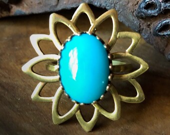 May include: A gold ring with a turquoise stone set in a flower-shaped design.