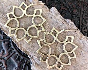 May include: A pair of gold-toned brass hoop earrings with a delicate, intricate design featuring a repeating pattern of teardrop shapes. The earrings are lightweight and have a simple, elegant style.