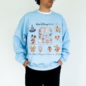 Light blue unisex pullover showing Mickey, Minnie, and Goofy icons for a 2026 family vacation aesthetic