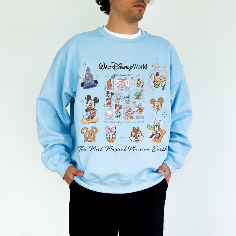 Light blue unisex pullover showing Mickey, Minnie, and Goofy icons for a 2026 family vacation aesthetic