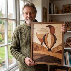 May include: A rectangular wooden wall art piece featuring an intricate marquetry design of two hot air balloons floating above a landscape. The artwork uses various shades of natural wood grain, including light maple, cherry, and dark walnut tones.