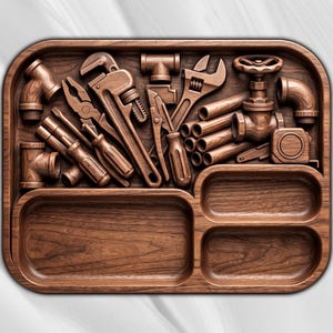 Op de afbeelding: Een rechthoekig houten organisator-dienblad met een uitgesneden reliëf van diverse loodgietersgereedschappen en buisfittingen, waaronder een pijptang, tangen, schroevendraaiers en een ventiel. Het dienblad bevat drie lege vakken.