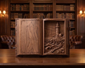 May include: A carved wooden book sculpture featuring a smooth left page with decorative border lines and a right page displaying a detailed relief carving of a lighthouse standing on a rocky coastline with crashing ocean waves.