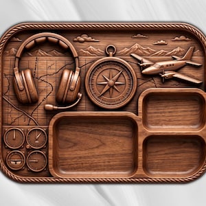 Puede incluir: Una bandeja rectangular de madera con un tema de viaje tallado que presenta auriculares, una brújula y un pequeño avión sobre un fondo de mapa. La bandeja incluye cuatro compartimentos distintos y cuatro indicadores circulares en el lado izquierdo.