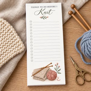 May include: A rectangular notepad with the text THINGS TO DO BEFORE I Knit at the top, featuring a list of checkboxes and lines. The bottom includes a printed illustration of a beige knitted swatch, pink yarn, and a small floral sprig.