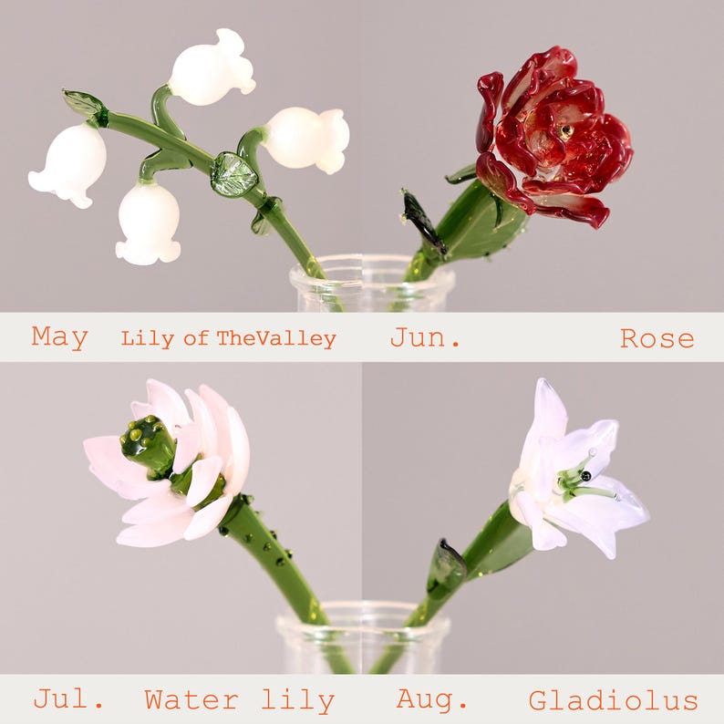 Puede incluir: Cuatro esculturas de flores de vidrio que representan los meses de nacimiento: lirio de los valles blanco para mayo, una rosa roja para junio, un nen&uacute;far rosa para julio y un gladiolo blanco para agosto. Cada flor tiene tallos y hojas de vidrio verde.