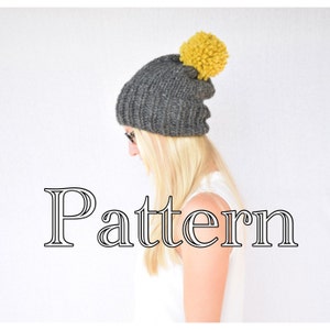 May include: A gray knitted beanie with a yellow pom pom. The beanie is slouchy and has a ribbed texture. The word "Pattern" is written in a decorative font below the beanie.