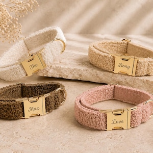 May include: Four personalized dog collars in cream, tan, brown, and pink. Each collar has a gold-colored buckle with a name engraved on it: Tho, Bong, Max, and Love. The collars are made of a soft, textured material.