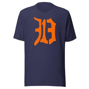 May include: Navy blue t-shirt with a large orange graphic of the number "313" in a stylized font. The short-sleeved shirt is made of a soft material and is suitable for casual wear.