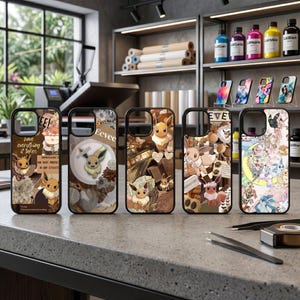 May include: A collection of five phone cases featuring Eevee and other Pokémon characters. The cases have black borders and various designs with brown, beige, and pastel colors. Some cases include text and collage elements.