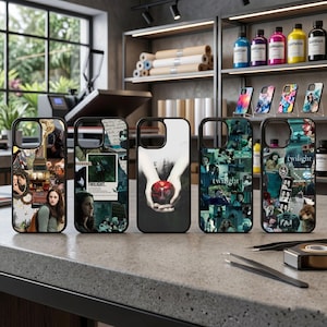 May include: Five black iPhone cases with Twilight-themed designs. The cases showcase images from the film series, including character collages, scenes, and the red apple. They are displayed on a grey countertop.