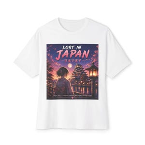 May include: White t-shirt featuring a graphic with the text "LOST IN JAPAN" above a Japanese scene with a woman, a pagoda, and a lantern. The phrase "NOT ALL THOSE WHO WANDER ARE LOST" is at the bottom.