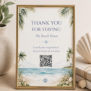 Puede incluir: Un letrero con marco dorado que muestra una escena de playa con palmeras, arena y olas del mar. El texto dice: THANK YOU FOR STAYING, The Beach House, Loved your experience? Scan to leave us a review, junto a un código QR en blanco y negro.