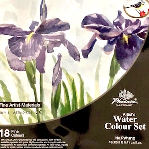 May include: A Phoenix brand artist's watercolor set box featuring a watercolor painting of purple iris flowers. The black packaging includes the text Fine Artist Materials, 18 Fine Colours, and No.PW1812 18x12ml 0.41 u.s.fl.oz. with a small bird icon.