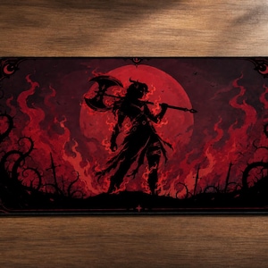 May include: A rectangular desk mat featuring a dark fantasy illustration of a horned figure holding a large double-bladed axe. The scene is set against a large red moon, surrounded by swirling red flames, thorny vines, and silhouettes of swords.
