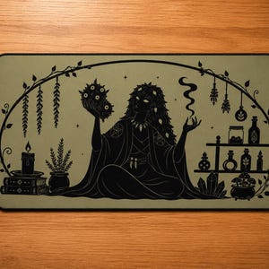 Può includere: Tappetino per mouse rettangolare nero e verde oliva con un'illustrazione di una strega. La strega è circondata da elementi mistici come candele, libri, pozioni e un cristallo. Il design ha un tema gotico e mistico.