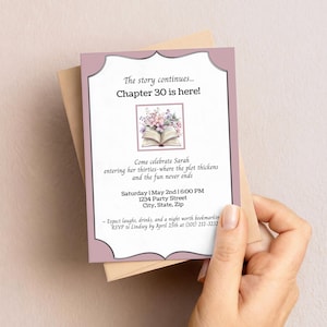 Pode incluir: Um cartão de convite malva e branco com o texto "The story continues... Chapter 30 is here!" e uma ilustração de um livro com flores. O cartão é segurado com um envelope de papel kraft. O convite é para uma festa de aniversário.