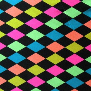 Pode incluir: Um tecido com um padrão repetitivo de diamantes de arlequim em cores neon vibrantes, incluindo rosa choque, verde lima, laranja brilhante e azul ciano, sobre um fundo preto sólido, criando um design geométrico de alto contraste.