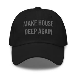 Op de afbeelding: Zwarte baseballpet met de tekst "MAKE HOUSE DEEP AGAIN" in grijze letters. De pet heeft een gebogen klep en een knoop aan de bovenkant. De hoed is gemaakt van een zacht materiaal.