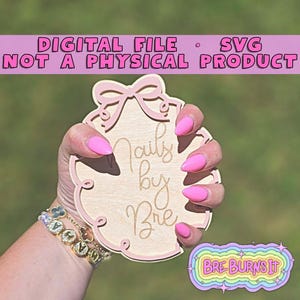 May include: A wooden sign with the text "Nails by Bre" in a cursive font, held by a hand with pink nails. The sign has a pink bow and border. The text "DIGITAL FILE • SVG NOT A PHYSICAL PRODUCT" is at the top. A rainbow sticker that says "BRE BURNS IT" is on the right.