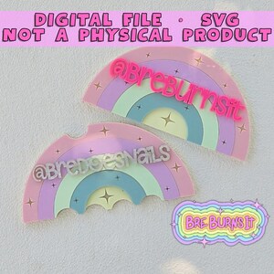 May include: Two semi-circular rainbow designs with pastel stripes and star accents. The top rainbow features the pink text @breburnsit, while the bottom rainbow displays the white text @bredoesnails. A small logo with the text BRE BURNS IT is included.