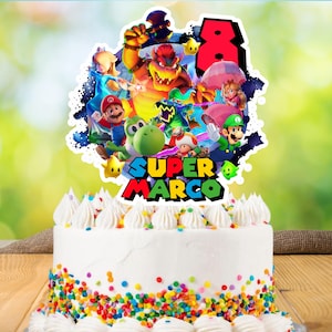 May include: A white frosted cake with colorful sprinkles and a Super Mario themed topper. The topper features various characters, the number 8, and the name "SUPER MARCO" in bold, colorful letters.