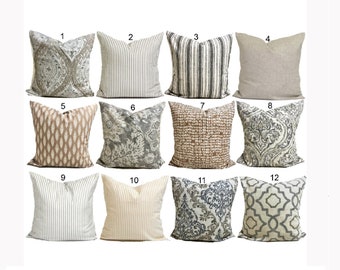 May include: A collection of twelve decorative throw pillows in various designs. Pillows feature patterns such as stripes, floral motifs, and geometric shapes. Colors include neutral tones like beige, gray, and white, suitable for home decor.