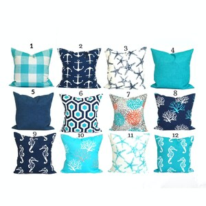 May include: A collection of twelve decorative throw pillows with various coastal-themed designs. Pillows feature patterns such as anchors, starfish, seahorses, coral, and geometric shapes in shades of blue, white, and turquoise. The pillows are square-shaped.