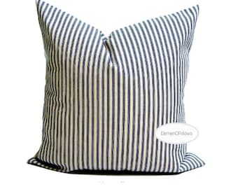 May include: A square cushion featuring a navy blue and white striped design. The cushion is a decorative item, suitable for a bed or sofa. The fabric has a soft, textured appearance. The cushion is likely measured in centimetres.