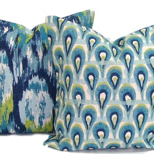May include: Two decorative throw pillows with a blue, green, and white geometric pattern. The pillow on the left has a more abstract pattern, while the pillow on the right has a repeating pattern of teardrop shapes.