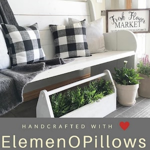 May include: A white bench with black and white buffalo check pillows and a gray throw blanket. A white wooden planter box holds green plants. A sign reads "Fresh Flower Market". The text "Handcrafted with ElememOPillows" is at the bottom.
