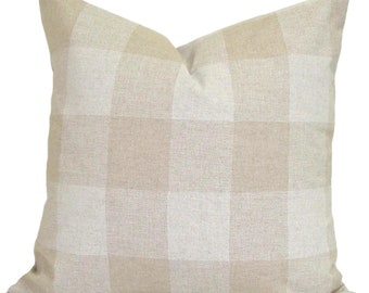 May include: A square decorative pillow with a beige and off-white checkered pattern. The pillow has a soft, textured appearance and is designed for home decor. The neutral color scheme makes it suitable for various interior styles.
