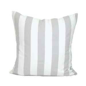 May include: A square cushion featuring a white and grey striped design. The cushion has a soft, textured appearance and is intended for decorative purposes. The stripes are vertical and evenly spaced across the cushion's surface.