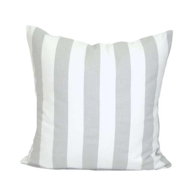 May include: A square cushion featuring a white and grey striped design. The cushion has a soft, textured appearance and is intended for decorative purposes. The stripes are vertical and evenly spaced across the cushion's surface.