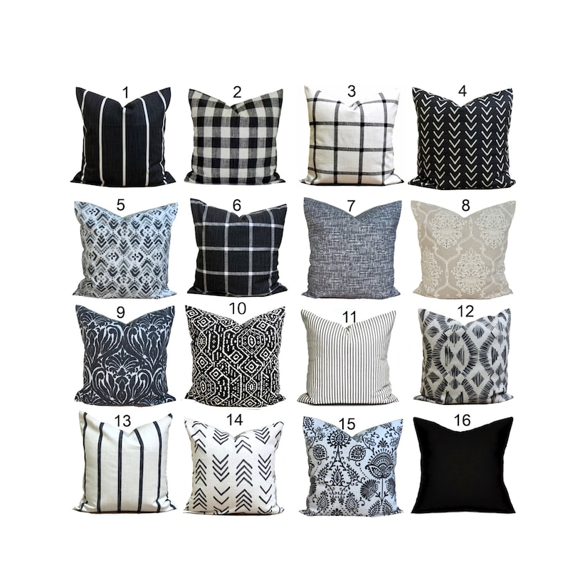 May include: Sixteen decorative cushions with diverse patterns. Designs include stripes, checks, geometric shapes, and floral motifs. Predominantly black, white, and grey, with one solid black cushion.