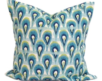 May include: Square decorative pillow with a repeating pattern of blue, teal, and green teardrop shapes on a white background. The pillow has a soft, textured appearance and is likely made of fabric.
