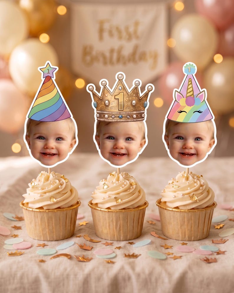 K&ouml;nnte beinhalten: Drei Cupcakes mit personalisierten Foto-Tortensteckern. Der linke Stecker zeigt ein Baby mit einem regenbogenfarbenen Partyhut mit Stern. Der mittlere Stecker zeigt ein Baby mit einer goldenen Krone und der Zahl 1. Der rechte Stecker zeigt ein Baby mit einem Einhorn-Partyhut.