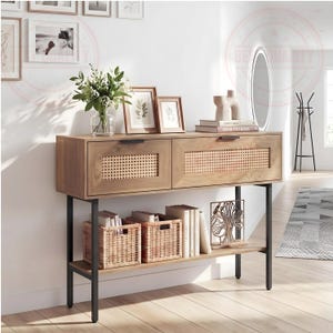 May include: A wooden console table featuring two drawers with woven cane panels and black metal handles. The table has a lower shelf holding two woven baskets and books. The frame is made of black metal legs, providing a sturdy base for the unit.